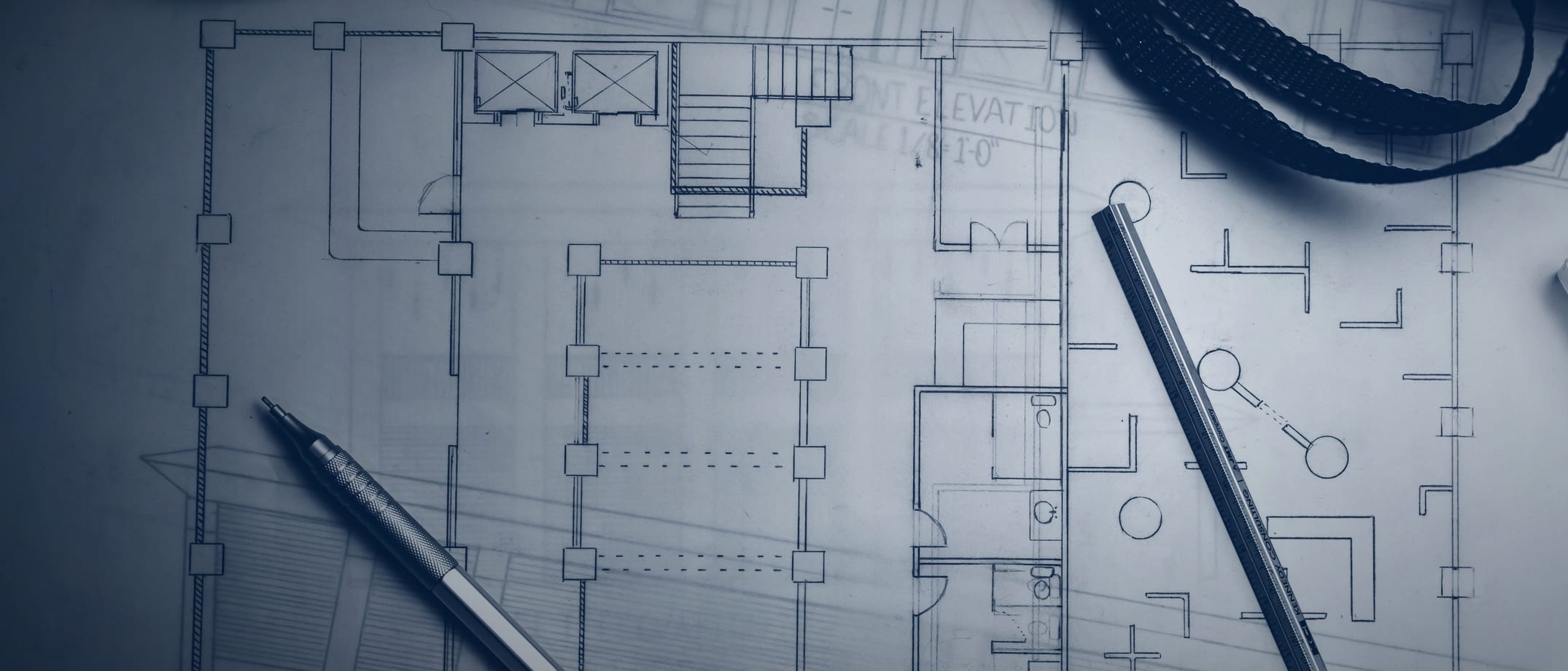 A hand-drawn floor plan with a mechanical pencil, a ruler and the strap of a drawing tube - nobody is shown.