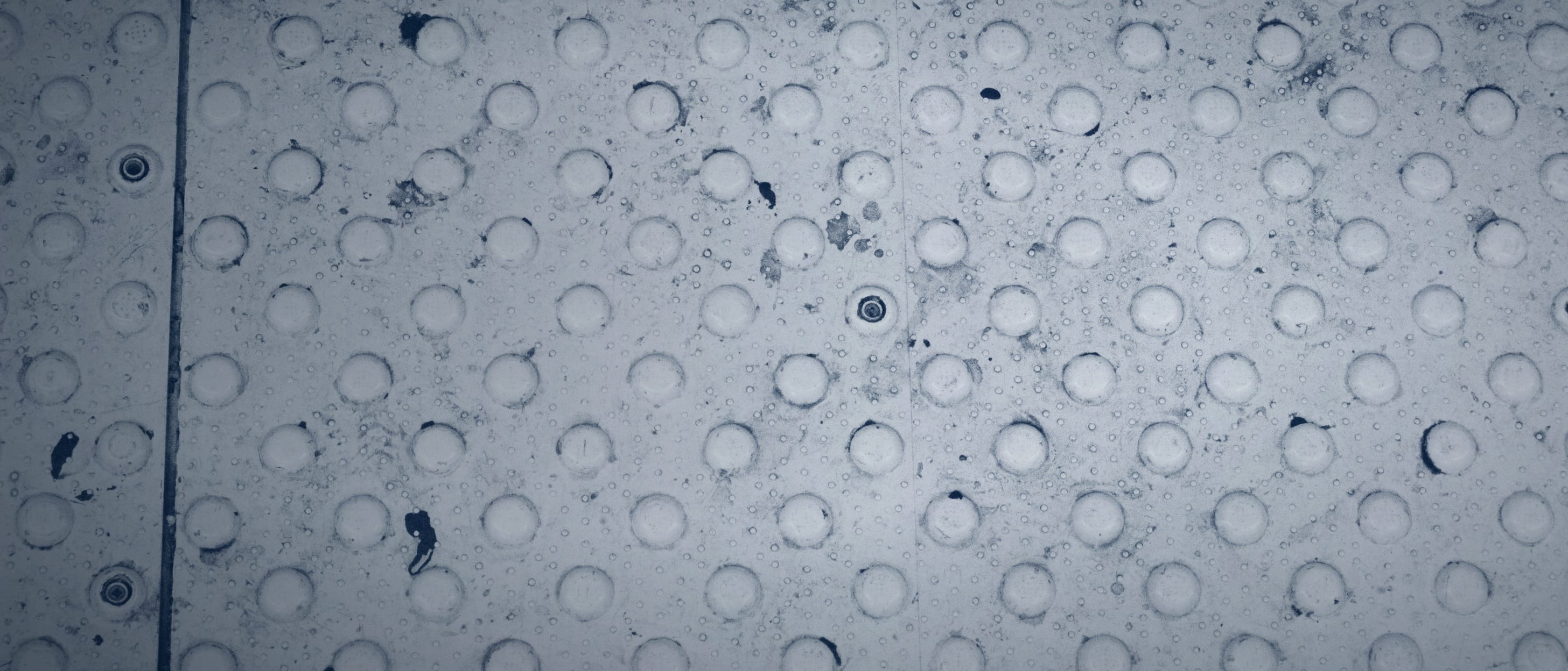 A tactile floor tile with round studs, as used in guidance systems for visually impaired people - nobody is shown.