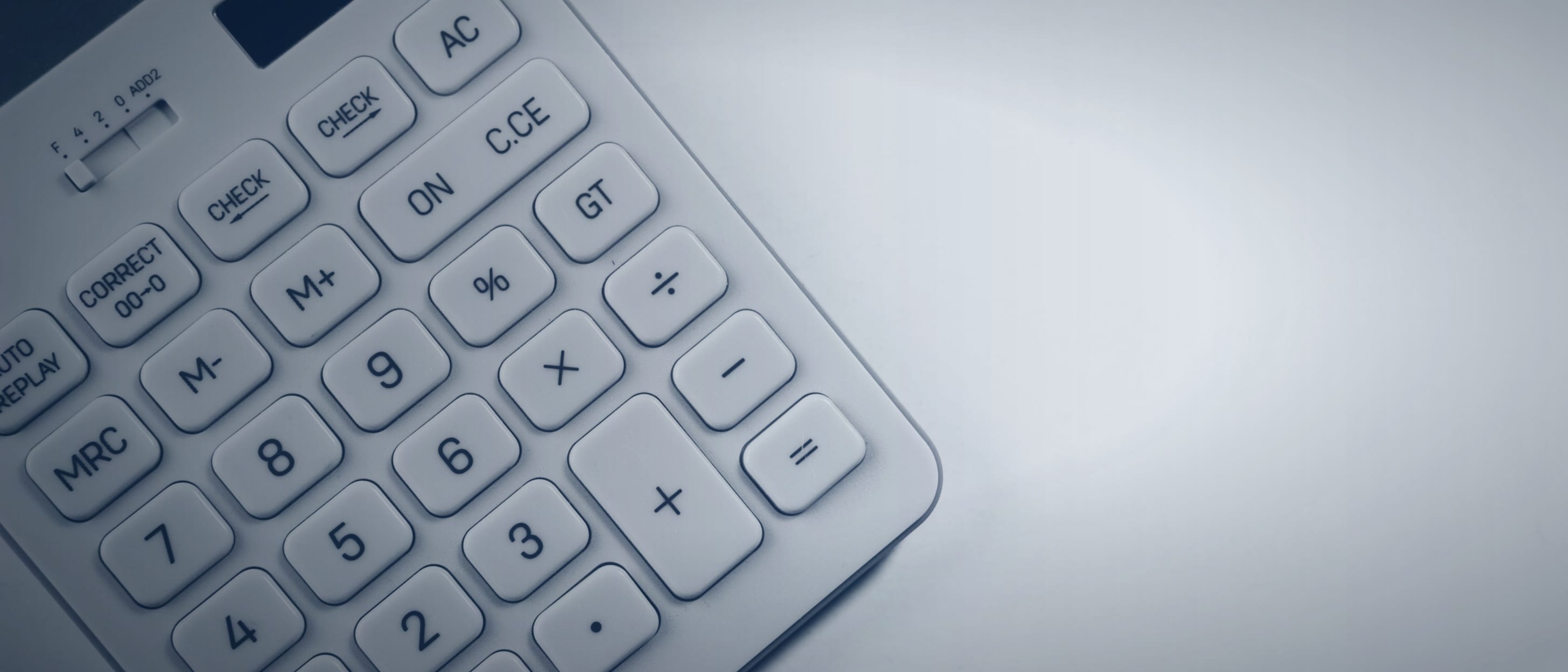 A desk calculator with large keys, photographed from above on a light surface - nobody is shown.